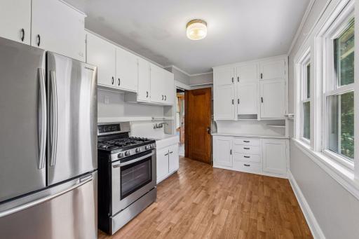 The inviting kitchen blends old-world charm with freshly painted cabinetry, creating a welcoming space for everyday living.