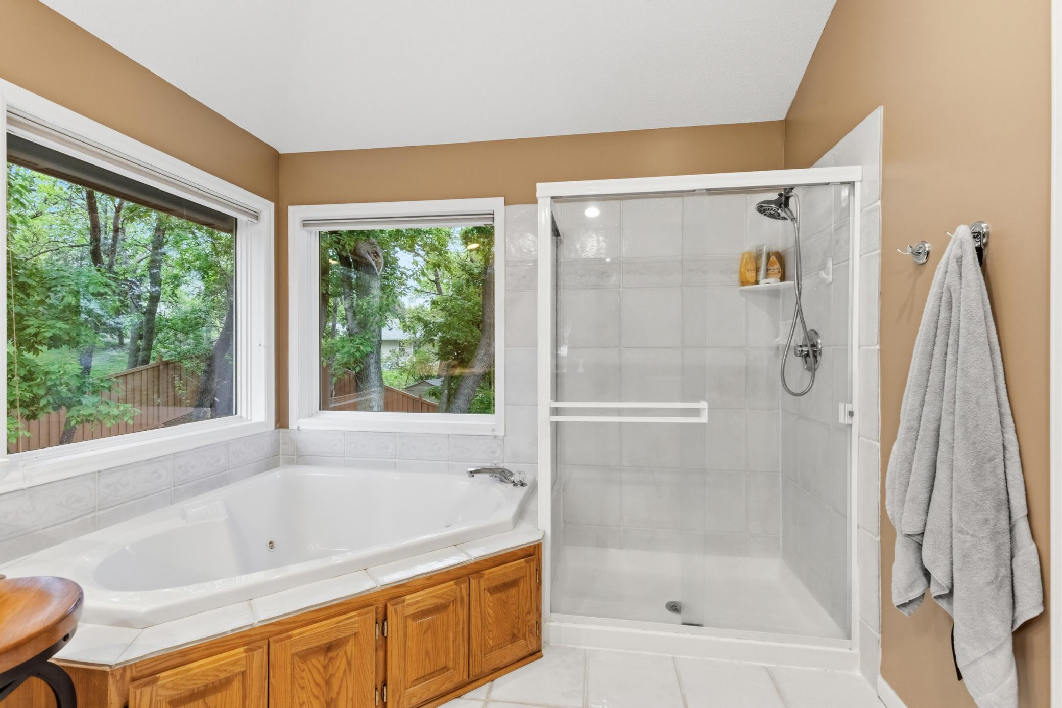 The ensuite bath has a separate tub and shower. Lots of windows with blinds. With the mature trees in the back that provide extra privacy.
