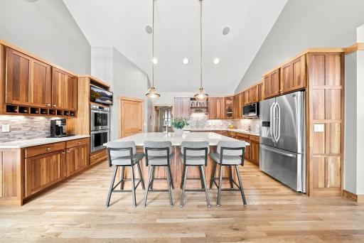 The beautifully updated kitchen is equally impressive with custom cabinetry, updated countertops and backsplash, stainless steel appliances, double ovens, an induction cooktop, a walk-in pantry, and an oversized center island designed for gathering.