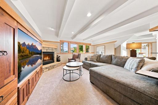The walkout lower level has a full bar/kitchen, a sun-filled sitting room with custom built-ins and a beautiful stone fireplace, updated baths, fitness or hobby room, abundant storage, and a private guest suite.