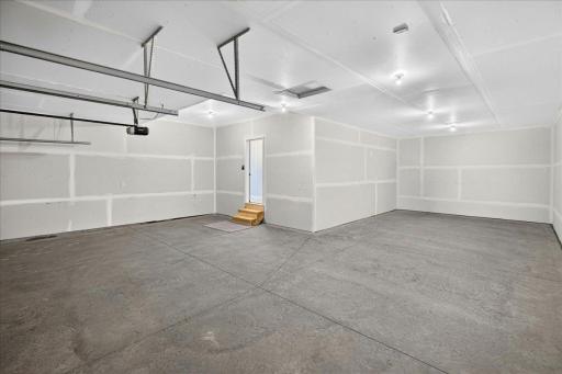 PHOTO OF A DIFFERENT HOME WITH SIMILAR PLAN & FINISHES. Spacious 4 BAY GARAGE (934 sq.ft.) offering an abundance of work space and storage! 3 stalls across the front of home and 4th bay tandem.