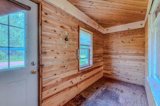 A spacious and inviting entryway featuring warm woodwalls that add natural character and a cozy, welcoming feel. Generous space provides plenty of room for seating, storage, and greeting guests.