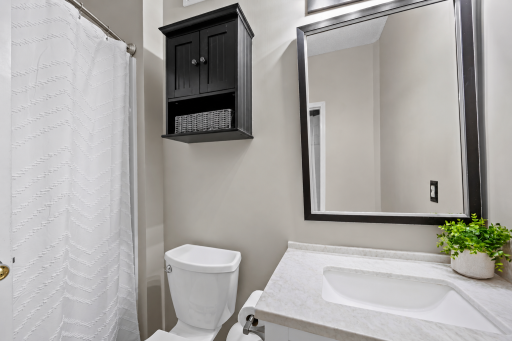 Main level primary bathroom. Upgraded countertops, fixtures. (Virtual staging has been used to help highlight this home's features)