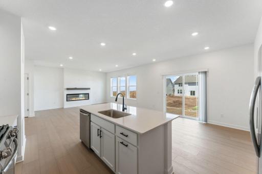 (Photo of a similar home, actual finishes may vary) The dining room features large glass sliders to bathe the space in natural light, perfect for meals at all times of day and night.