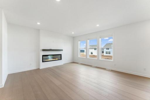 (Photo of a similar home, actual finishes may vary) An electric fireplace stands ready to provide warmth during colder months
