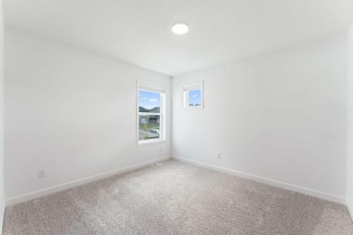 (Photo of a similar home, actual finishes may vary) This bedroom is conveniently steps away from the full-sized bathroom and tech space on the second level.