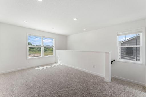 (Photo of a similar home, actual finishes may vary) The loft can be found at the top of the stairs, offering a versatile shared living area that everyone can enjoy.