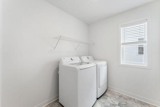 (Photo of a similar home, actual finishes may vary) The laundry room is centrally located with ventilated shelving and washer-dryer hook-ups to simplify household chores.