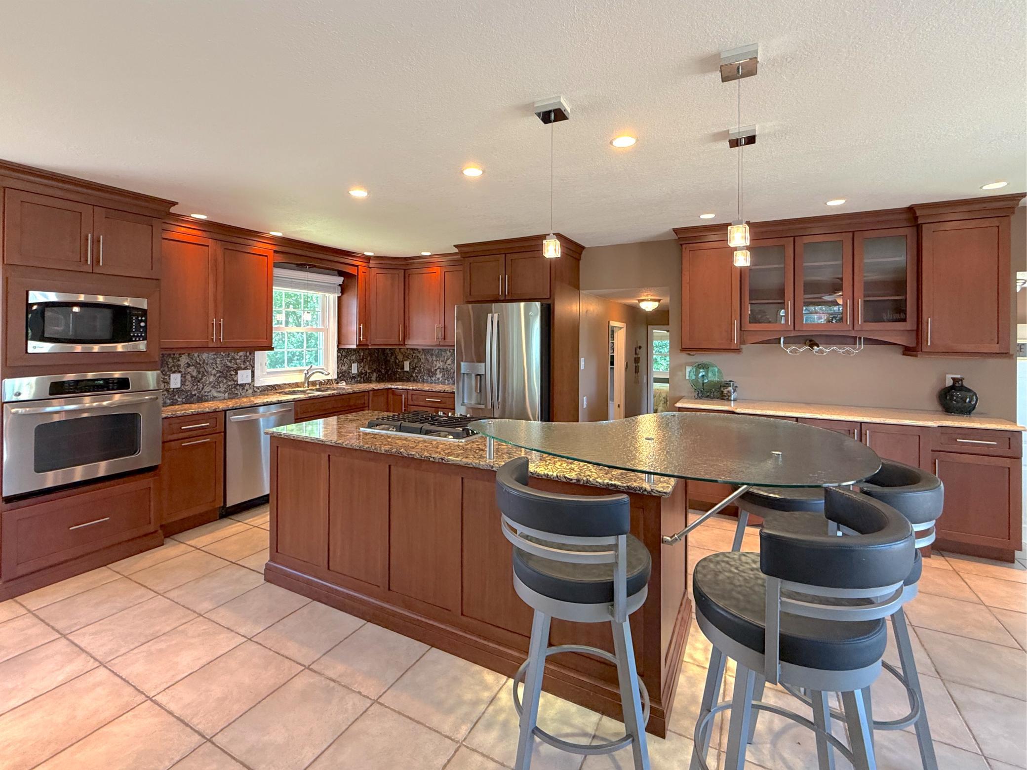 The beautifully updated kitchen is designed for effortless entertaining, featuring abundant cabinetry, granite countertops and tile flooring.