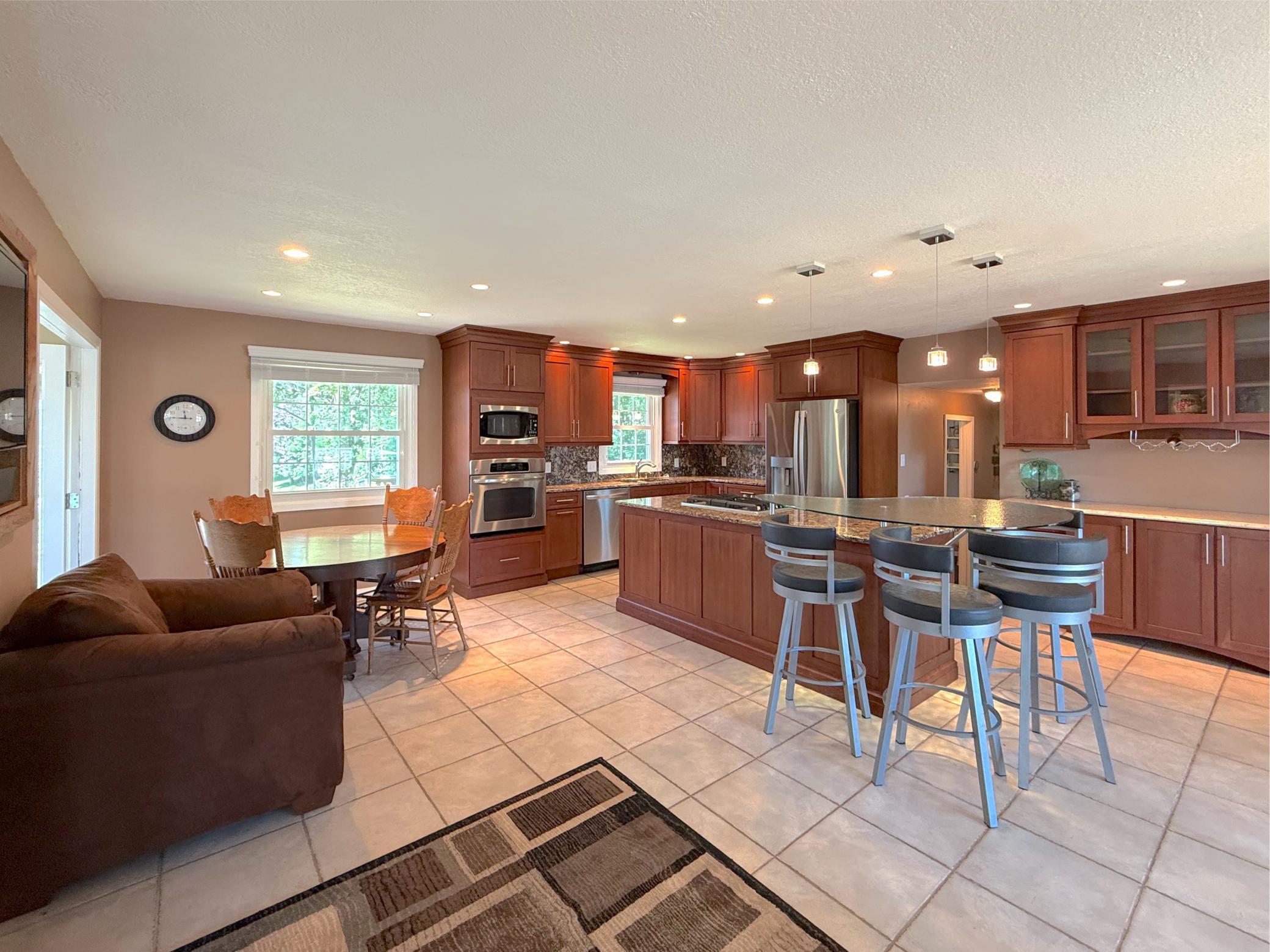 A spacious center island anchors this impressive kitchen, offering generous prep space, and seating. Rich cabinetry, stainless steel appliances complete the space.