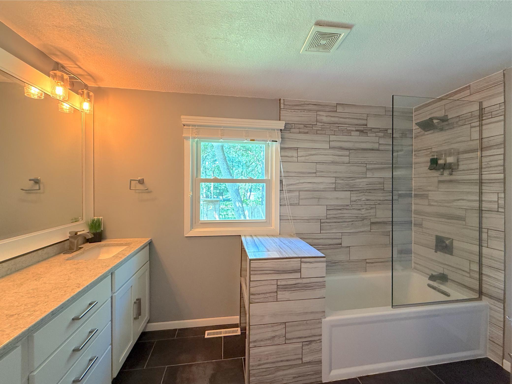 The beautifully remodeled main-level bathroom combines modern finishes with everyday functionality. A custom double-sink vanity and stunning tile create a spa-like retreat.