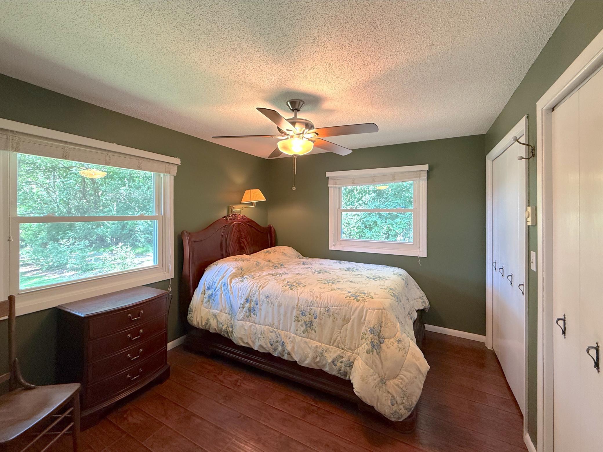 The main-level primary bedroom offers a peaceful retreat with large windows overlooking the beautifully wooded yard. Generous closet space and warm finishes create a comfortable space.