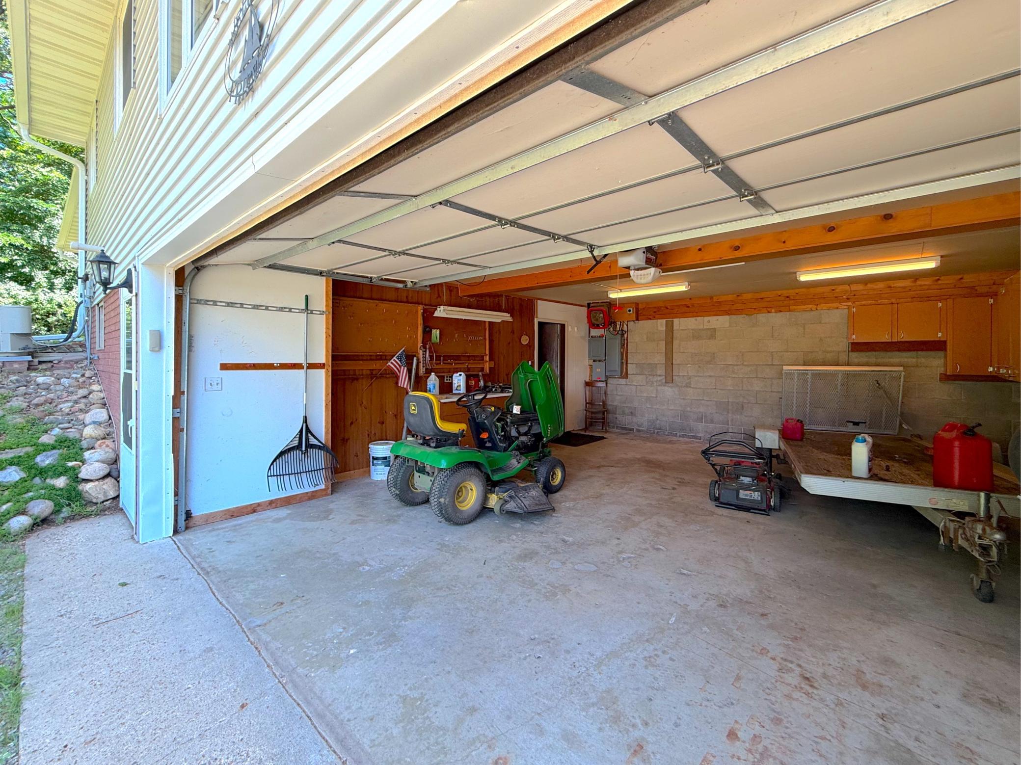 The spacious attached garage provides plenty of room for vehicles, lake toys, and outdoor equipment. Built-in cabinetry and work areas offer excellent storage and organization for every season.