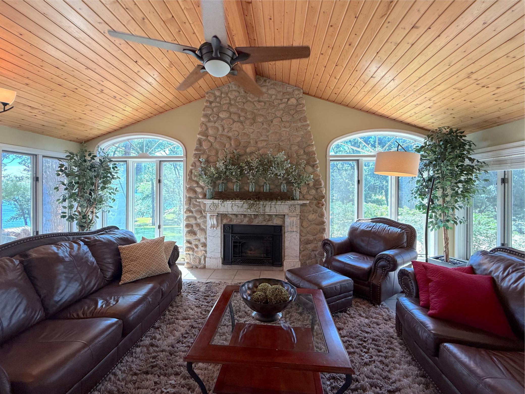 A floor-to-ceiling stone gas fireplace serves as the stunning focal point of the living room, framed by soaring windows that showcase picturesque views of Lake Sylvia.