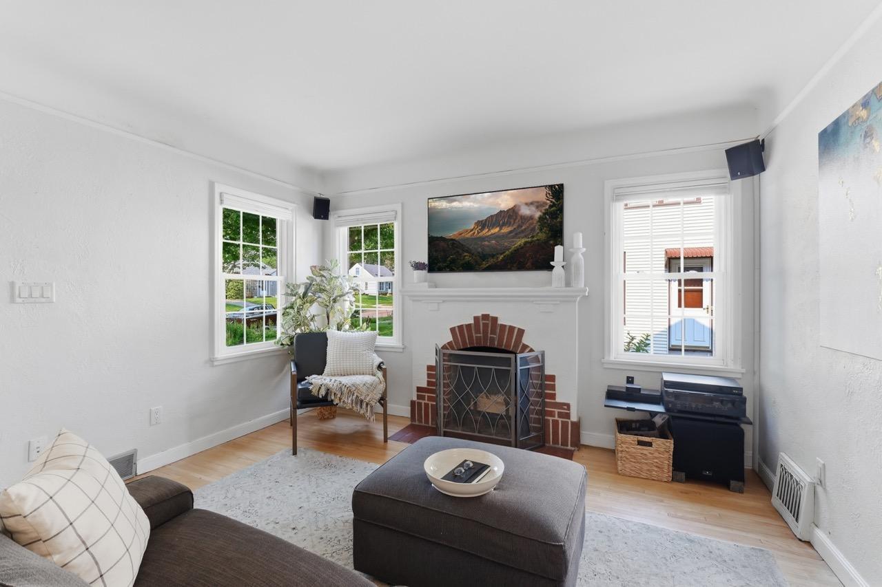 view of living room and wonderful green views to the Southwest and Original Brick Fireplace with tastefully integrated 5.1 Surround sound system for immersive movie expeirence with the Samsung TheFrame Smart TV.