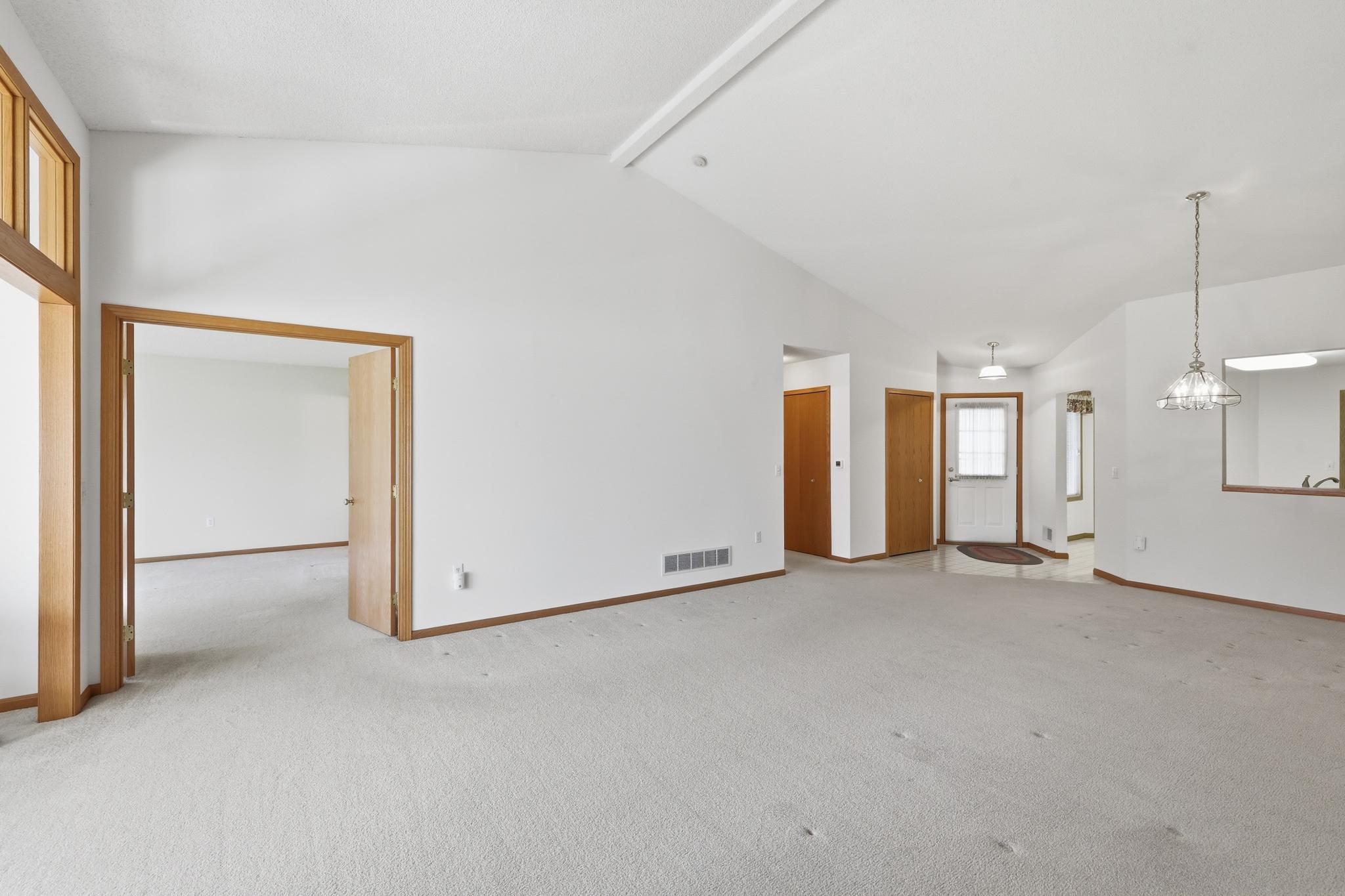 Alternate view of the living and dining room. Double doors open to the primary suite.