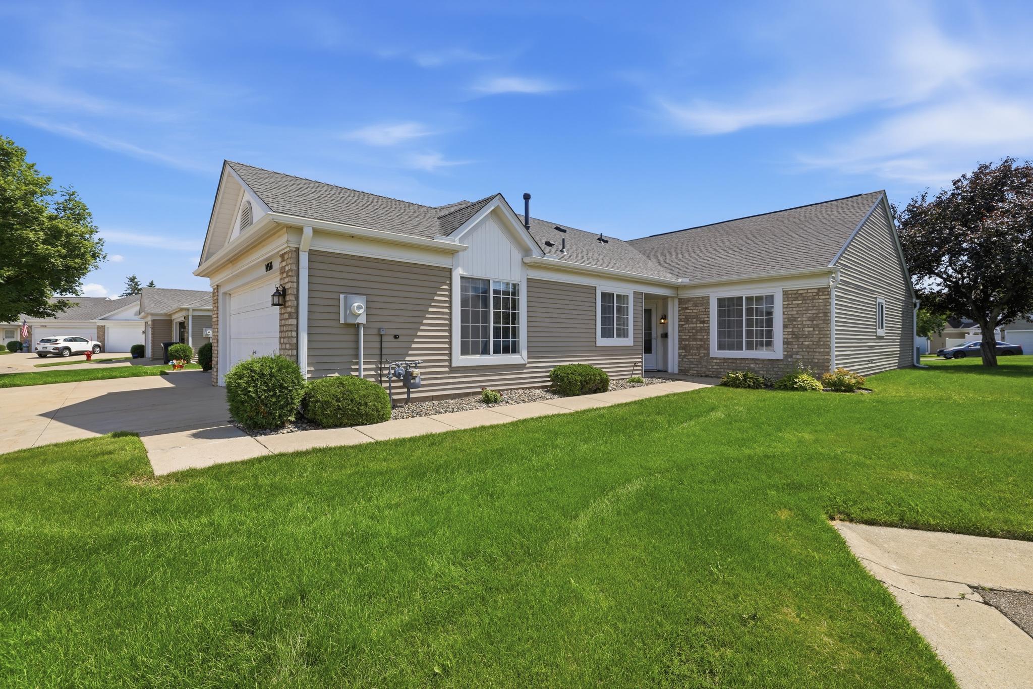 Inviting front entry framed by tidy landscaping and a wide, level walkway for step-free access.