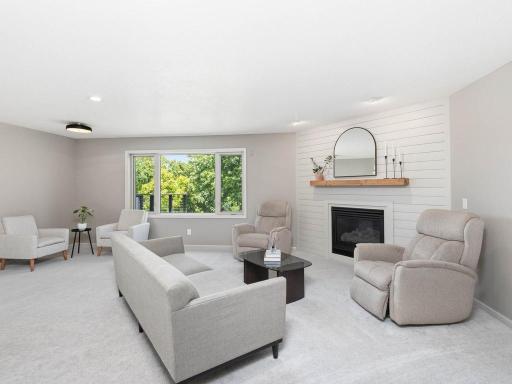 Gas fireplace with white shiplap surround and wood mantle creates a natural focal point within the living room.