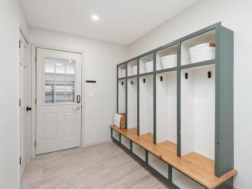 Garage entry opens to a functional mudroom featuring tile floor for easy clean-up and custom built-in storage lockers with bench seating for everyday organization.