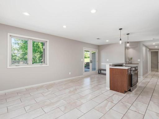 Finished Walkout LL living area features tile flooring, natural light, and direct access to the backyard patio.