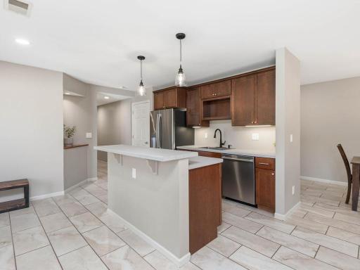 Second kitchen includes SS appliances, cabinetry, and breakfast bar seating.