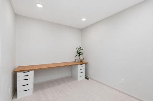 Main-level office offers flexible space for working from home, reading, hobbies, or everyday organization. This photo was AI enhanced to remove a chair.