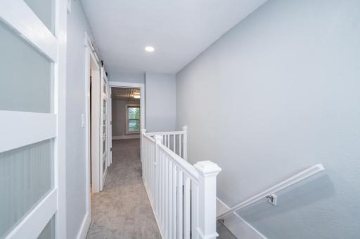Upper level hallway w/modern sliding doors, maintenance free railing & new carpet