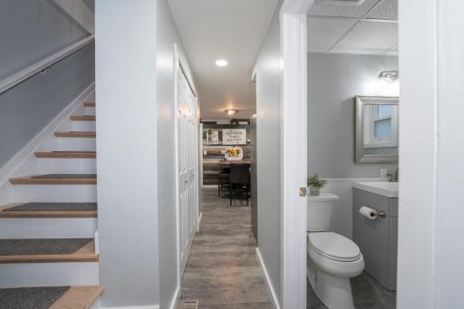 Hallway showing stairs to upper level and 1/2 bath to right.