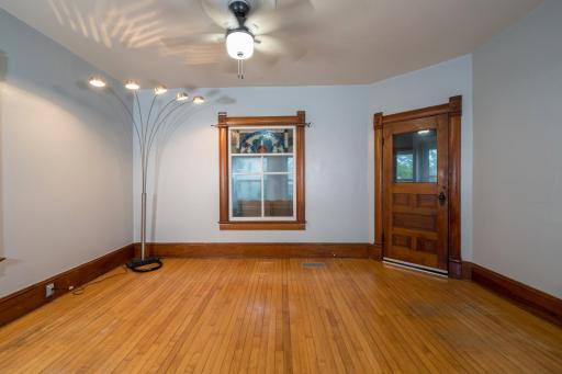 Living Room with original wood front door and upper stained glass window