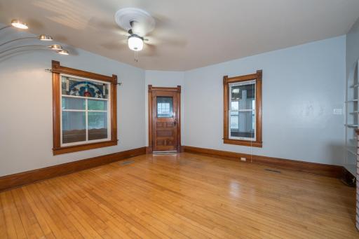 Living Room with original wood floors, front door and stained glass upper window.
