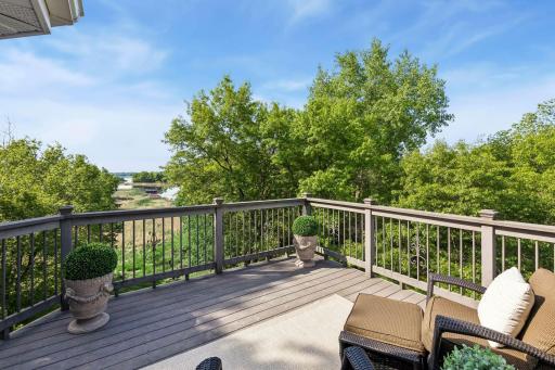 This primary suite is exceptional, featuring a spacious bedroom, a cozy reading nook, and a warm, spa-like bath with a separate tub and shower. Step out onto the private maintenance-free balcony and take in sweeping views of the 1+ acre lot and Lake