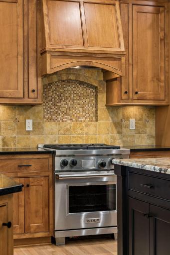 A stunning stone niche above the Wolf range adds warmth, texture, and timeless appeal.