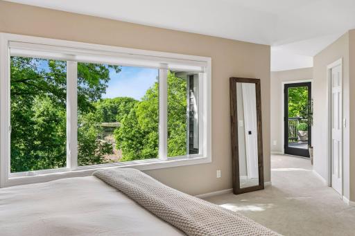 This primary suite is exceptional, featuring a spacious bedroom, a cozy reading nook, and a warm, spa-like bath with a separate tub and shower. Step out onto the private maintenance-free balcony and take in sweeping views of the 1+ acre lot and Lake