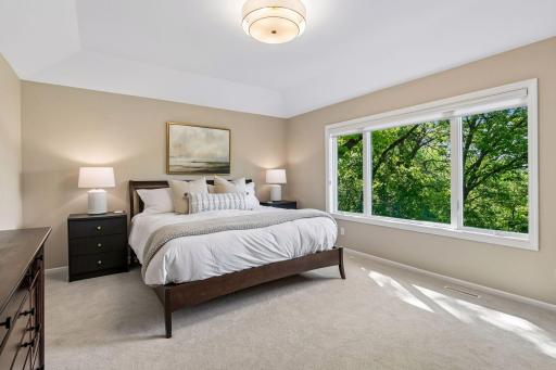 This primary suite is exceptional, featuring a spacious bedroom, a cozy reading nook, and a warm, spa-like bath with a separate tub and shower. Step out onto the private maintenance-free balcony and take in sweeping views of the 1+ acre lot and Lake