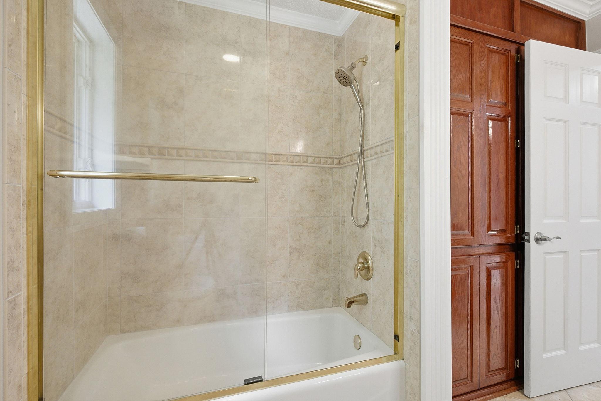 Upper-level full bath featuring heated tile floors and ample space for family or guests.