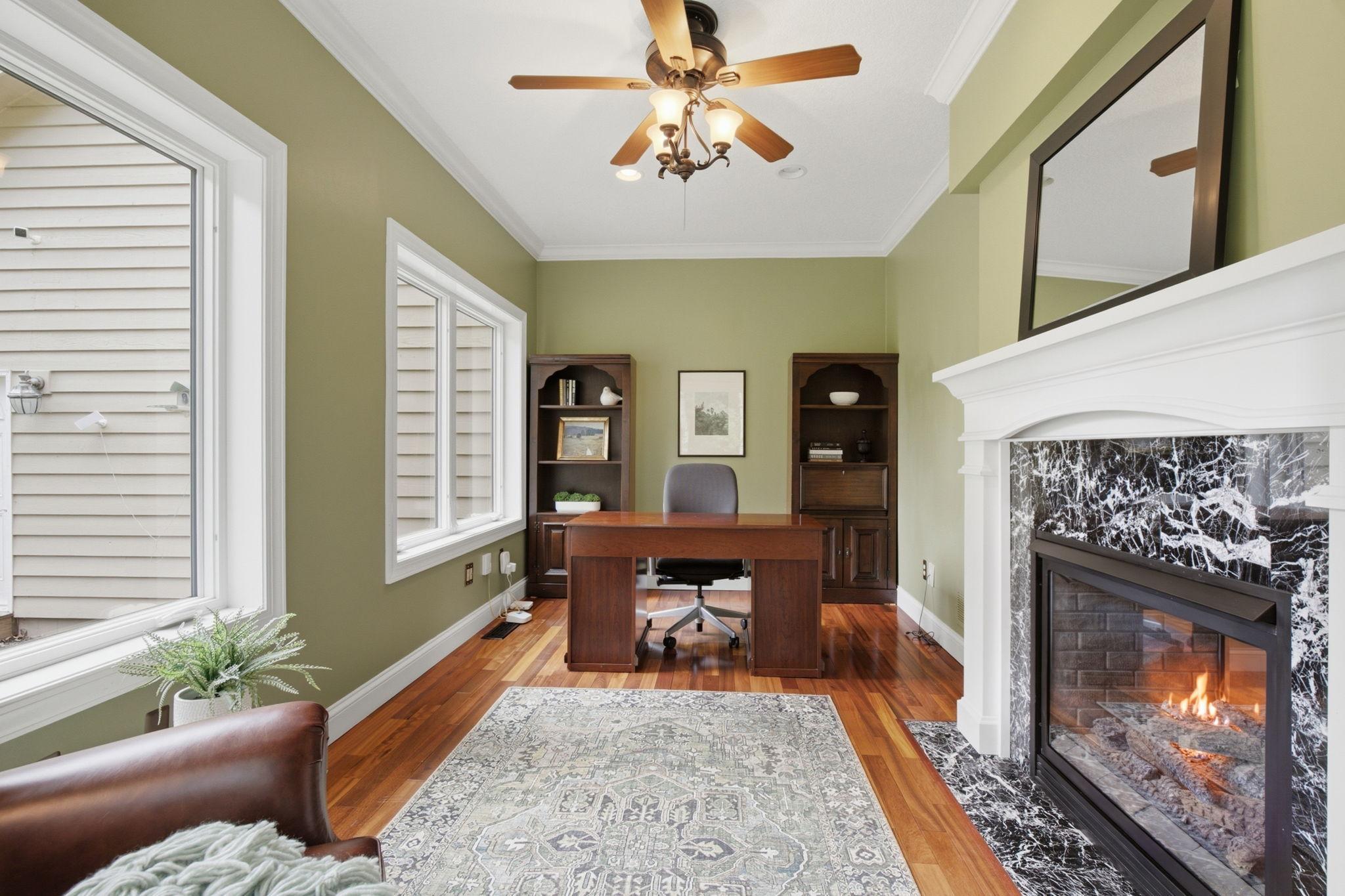 Versatile main-floor office features a cozy two-sided gas fireplace. Or sunroom