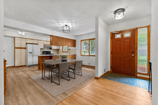 The spacious layout is filled with natural light and has been extensively refreshed throughout with touches of vintage moments. This virtually staged dining showcases the new LVP flooring and light fixtures.