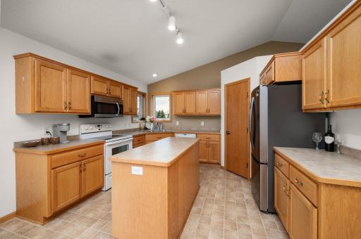 Functional kitchen equipped with a center island, wood cabinetry, stainless steel appliance accents, and ample counter space