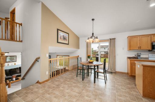 Open-concept dining space with vault ceiling accents, great natural light, and direct walkout access to the backyard deck.