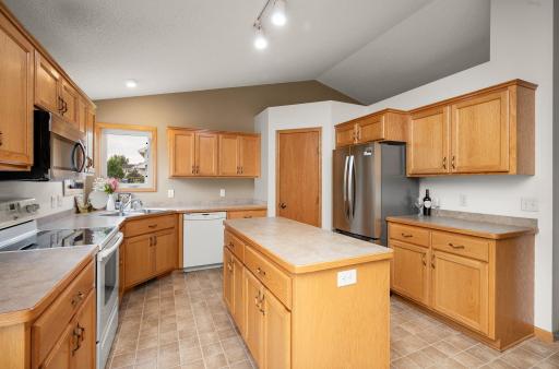 Kitchen view highlighting the center island, dishwasher, and nearby corner pantry storage