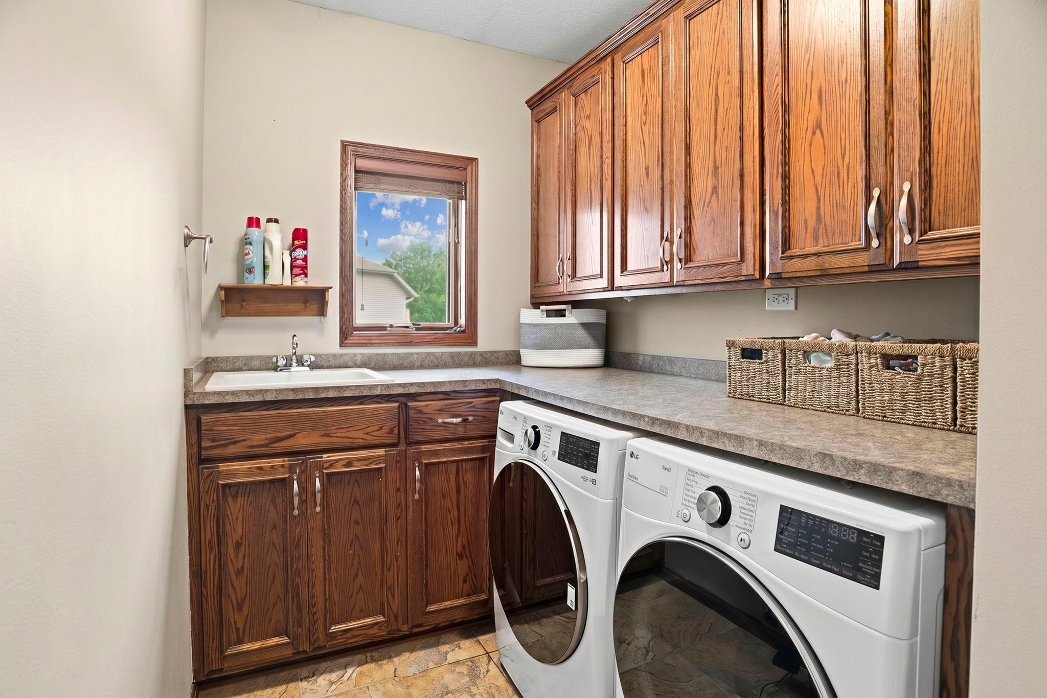 The convenient main floor laundry with cabinetry and sink.