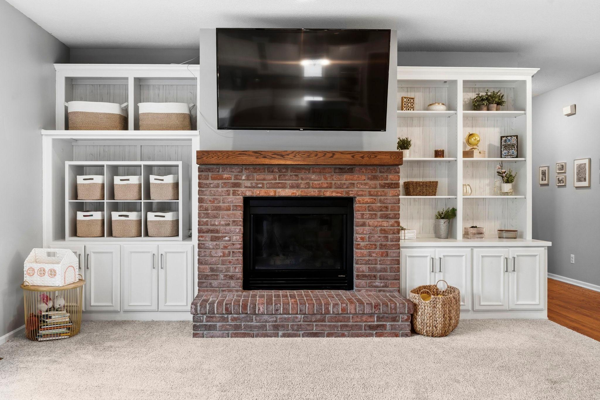 The living room has a gas fireplace with built in cabinetry on either side.