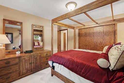 Dresser, bed and two nightstands easily fit in spacious primary bedroom - hardwood flooring under the carpet.