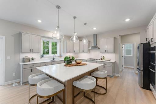 (Photo of a similar home, actual finishes may vary) Melding seamlessly with a breakfast room for casual meals, the sunlit kitchen comes equipped with popular features and a spacious pantry that makes it equal parts functional and stylish.