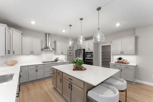 (Photo of a similar home, actual finishes may vary) The gourmet kitchen showcases a microwave atop a single wall oven, perfect for whipping up delicious feasts of all sizes