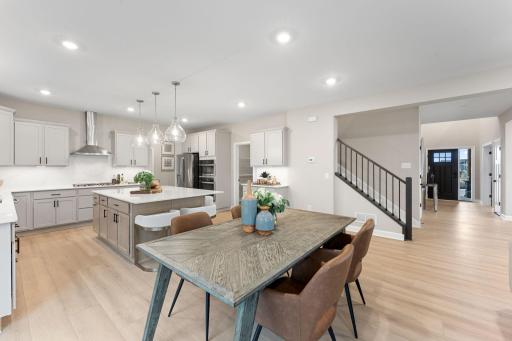 (Photo of a similar home, actual finishes may vary) Situated in front of glass sliders, this breakfast room provides an idyllic place for sun-dappled meals that can venture out to the backyard.