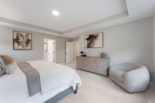 (Photo of a similar home, actual finishes may vary) A grand tray ceiling provides a sophisticated touch to the primary bedroom
