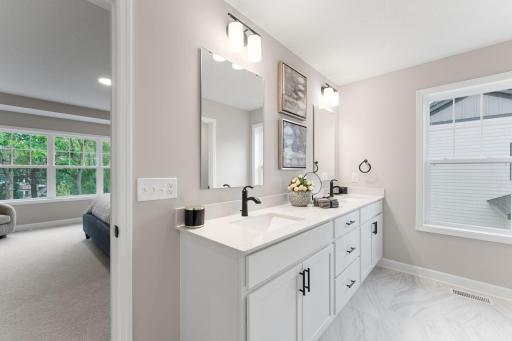 (Photo of a similar home, actual finishes may vary) Double sinks, MoenÂ® brushed-nickel faucets and quartz countertops gleam in the ownerâs suite bathroom