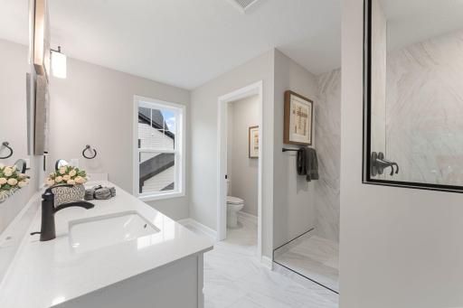 (Photo of a similar home, actual finishes may vary) The upgraded Serenity shower contributes to a spa-like atmosphere