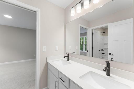 (Photo of a similar home, actual finishes may vary) Well-equipped with dual sinks, this Jack-and-Jill style bathroom is shared by two secondary bedrooms and can only be accessed through them.